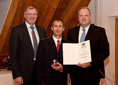 Drei Personen posieren für ein Foto bei der Ehrung von Thomas Wagmüller