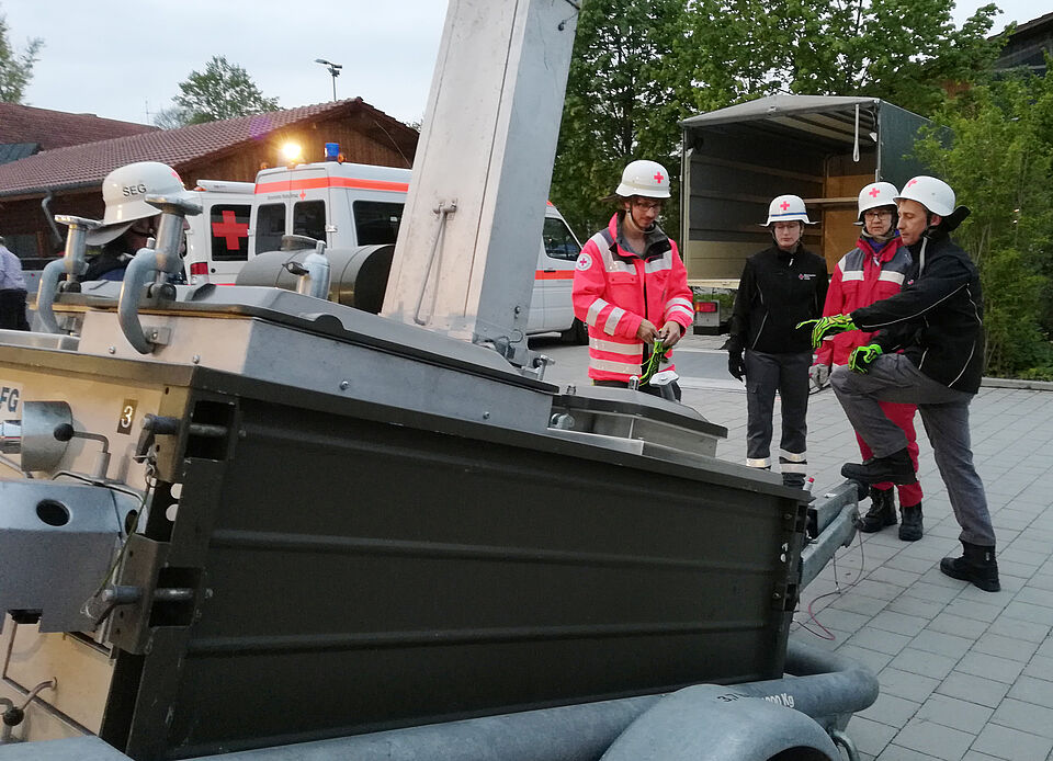Rotkreuzhelfer*innen beim Absetzen des Feldkochherdes